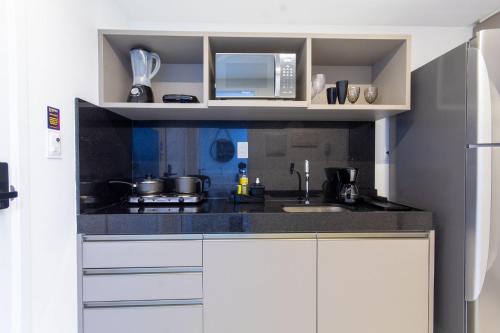 a kitchen with a sink and a microwave at Unity #421 - Praia de Cabo branco por Carpediem in Penha