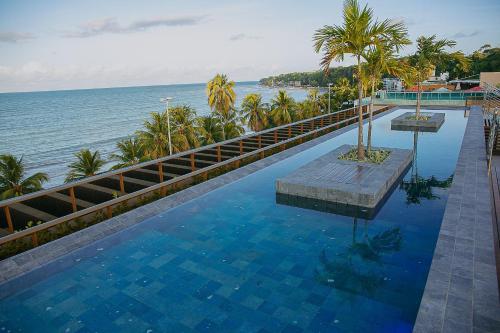 a swimming pool with a view of the ocean at Unity #421 - Praia de Cabo branco por Carpediem in Penha