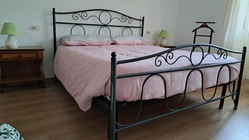 a bedroom with a black bed with a pink comforter at Casa Lino in Premia