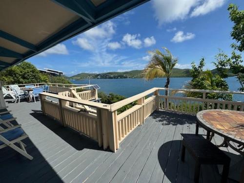 a deck with a table and a view of the water at Emma by the Bay in Culebra