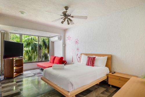 een slaapkamer met een bed en een flatscreen-tv bij Large House - walking to beach - 10 guests! in Cancun