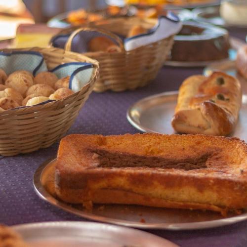 a table with plates of bread and baskets of snacks at Hotel Garni Cruzeiro do Sul in Paraty