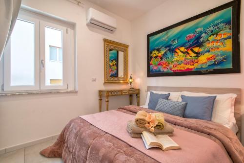 a bedroom with a large bed with a book at Casa mare & spa Alghero in Alghero