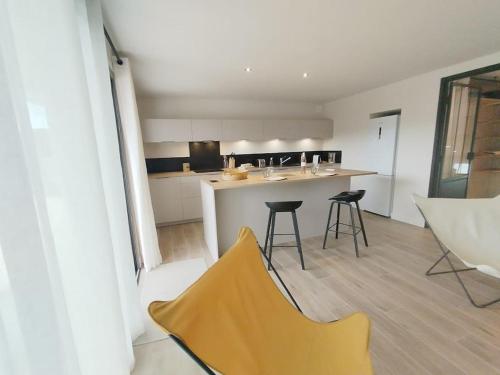 een keuken met een aanrecht en stoelen in een kamer bij T2 neuf, 1 chambre, golf Valcros in La Londe-les-Maures