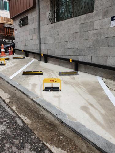a concrete slab with yellow barriers on a street at Hyelang House in Seongnam