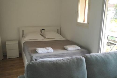 een slaapkamer met een bed, een bank en een raam bij Terrasse ensoleillée et accès à la piscine vue mer in Vallauris