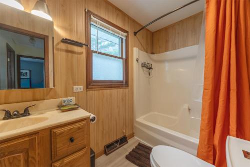 a bathroom with a sink and a tub and a toilet at Silver Woods - New Vacation Rental - Lake Access Half a Mile away in Fennville