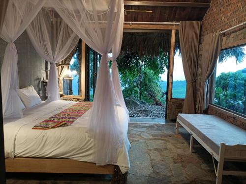 een slaapkamer met een hemelbed en een raam bij Pu Luong Paradise in Hương Bá Thước
