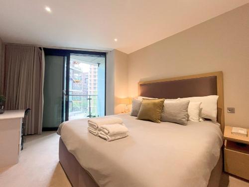 una camera da letto con un grande letto bianco e una finestra di Riverside Oasis walk to Battersea Power Station a Londra