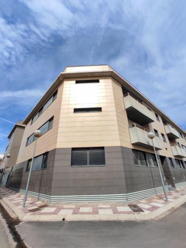 a tan building with two street lights in front of it at Lo piset del Delta: Apartamento con piscina para 4 in L'Aldea
