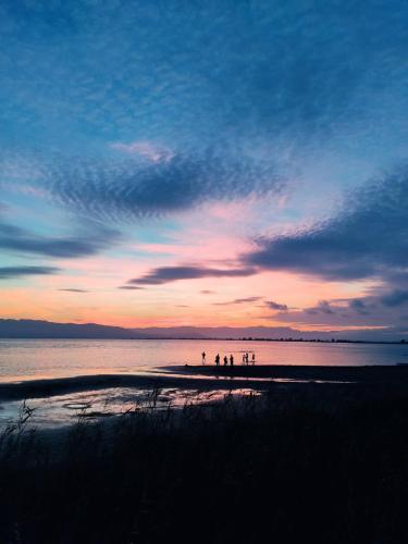 a group of people standing on a beach at sunset at Lo piset del Delta: Apartamento con piscina para 4 in L'Aldea