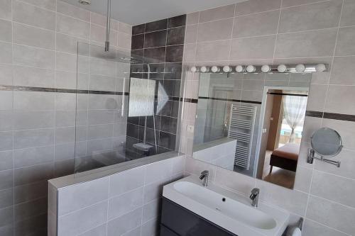une salle de bain avec un lavabo et un miroir dans l'établissement Maison proche Océan avec piscine, à Saint-Médard-en-Jalles