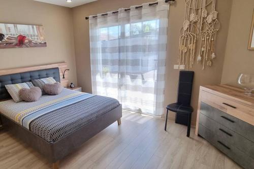 une chambre avec un lit, une commode et une fenêtre dans l'établissement Maison proche Océan avec piscine, à Saint-Médard-en-Jalles