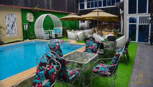 een zwembad met stoelen en een tafel en een parasol bij Dreams hotel in Douala