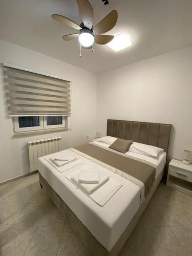 a bedroom with a bed with a ceiling fan at Villa Lipovac Trogir in Trogir