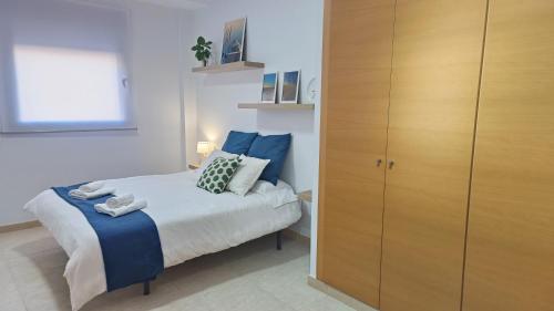 a bedroom with a bed and a wooden cabinet at Lo piset del Delta: Apartamento con piscina para 4 in L'Aldea