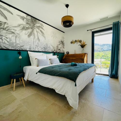 une chambre avec un grand lit et une grande fenêtre dans l'établissement Gite La Madeleine du Luberon., à Lioux