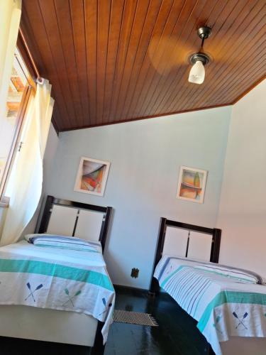 Duas camas num quarto com tecto em madeira em Casa completa em Peró! em Cabo Frio