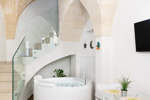 baño con bañera blanca y escaleras en La Pala Suite Apartment, en Leporano