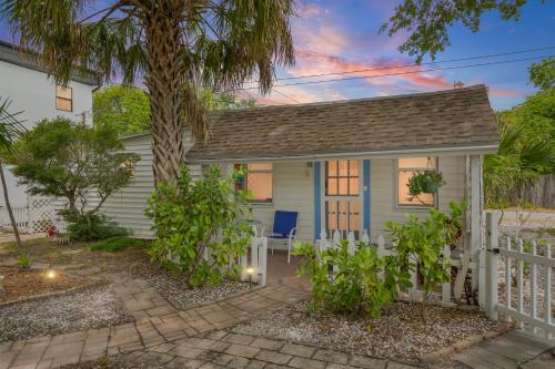 ein kleines Häuschen mit einem Zaun und einer Palme in der Unterkunft Little Pineapple Cottage in St Petersburg