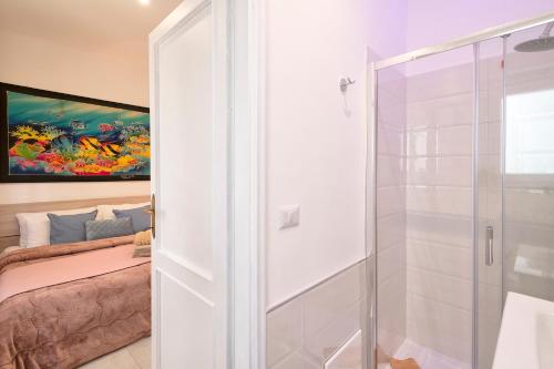 a bathroom with a glass shower and a bed at Casa mare & spa Alghero in Alghero