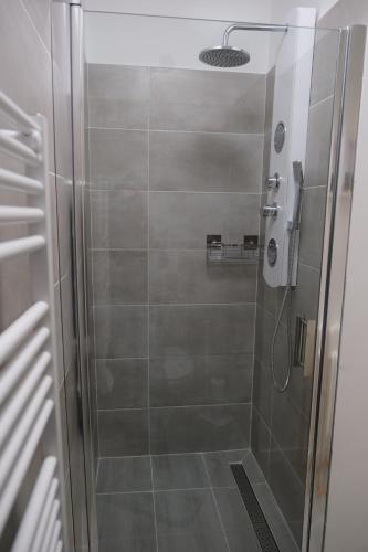 een douche met een glazen deur in de badkamer bij La Fontaine in Hauteville-Lompnes
