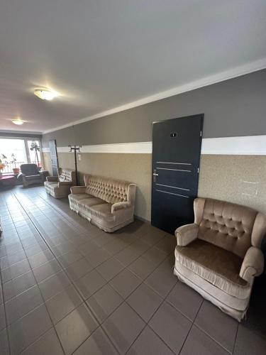 a waiting room with couches and chairs in a building at Zajazd Restauracja Derby in Błonie