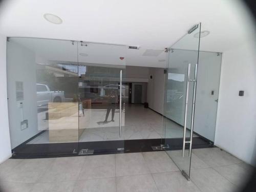 a glass wall in a room with a person in it at Departamento con jacuzzi 5 piso Condado 2 habitaciones in Quito