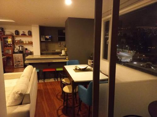 a living room and kitchen with a couch and a table at Departamento con jacuzzi 5 piso Condado 2 habitaciones in Quito