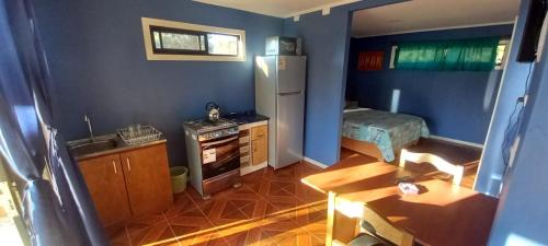 uma pequena cozinha com um frigorífico e uma mesa em Cabañas con Tinaja, 2 a 4 Personas em Quillón