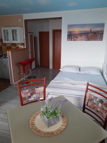 een kamer met een tafel, 2 stoelen en een bed bij Apartmani Kalajevo in Crikvenica