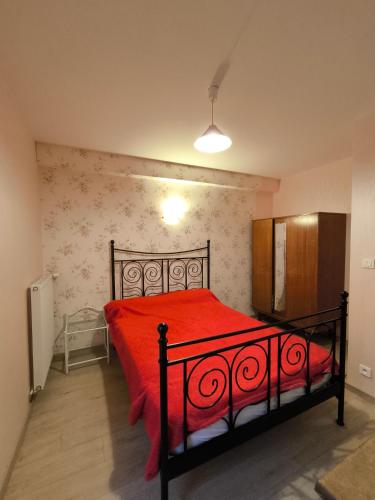 une chambre avec un lit avec une couette rouge dans l'établissement Maison au pied de la vielle ville du Puy en Velay, au Puy-en-Velay