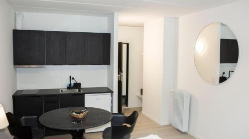 - une cuisine avec une table, des chaises et un miroir dans l'établissement A Hotels Apartments Høje Taastrup, à Tåstrup