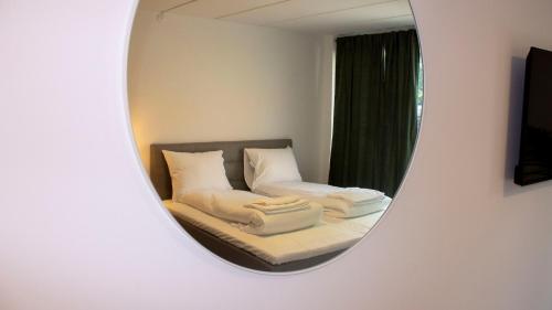 um reflexo de espelho de uma cama num quarto em A Hotels Apartments Høje Taastrup em Tåstrup