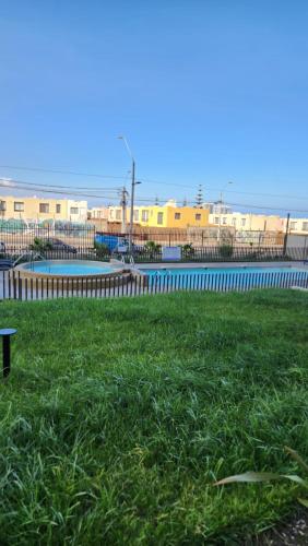 een park met een hek en groen gras bij Ayleen Suite in Antofagasta