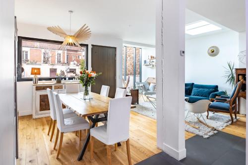 une salle à manger et un salon avec une table et des chaises dans l'établissement Superbe maison d'architecte familiale près de Paris, à Gentilly