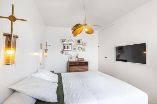 une chambre avec deux lits et une télévision à écran plat dans l'établissement Superbe maison d'architecte familiale près de Paris, à Gentilly