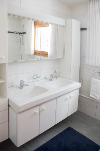 a white bathroom with a sink and a mirror at Holiday apartment La Costa Valbella- Lenzerheide in Valbella