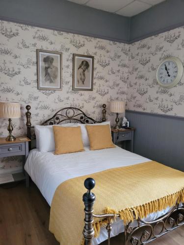 a bedroom with a bed with two tables and a clock at J's Mayfair Guest House in Blackpool