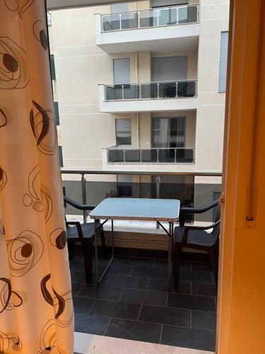 a table and chairs on a balcony with a building at Sea View Apartments in Durrës