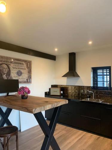 a kitchen with a wooden table and a sink at tuinhuis in Harmelen