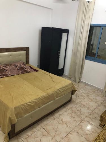 1 dormitorio con 1 cama, vestidor y ventana en Al Majaz King Size Room en Sharjah