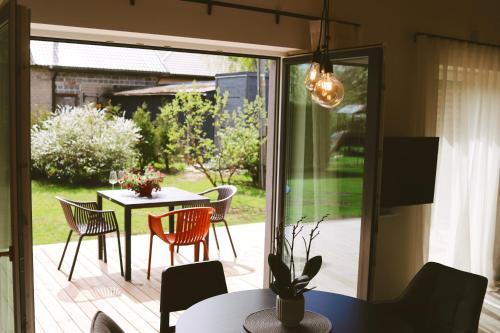 eine Terrasse mit einem Tisch, Stühlen und einer Glastür in der Unterkunft Tūristu apartamenti in Sigulda
