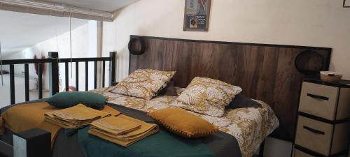 uma cama com almofadas num quarto em La Margotière em Draguignan