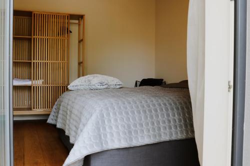 una camera da letto con un letto e un piumone bianco di Tūristu apartamenti a Sigulda