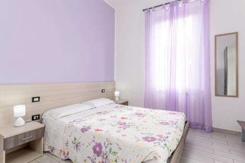 a white bedroom with a bed and a window at La Casa di Bianca in Follonica
