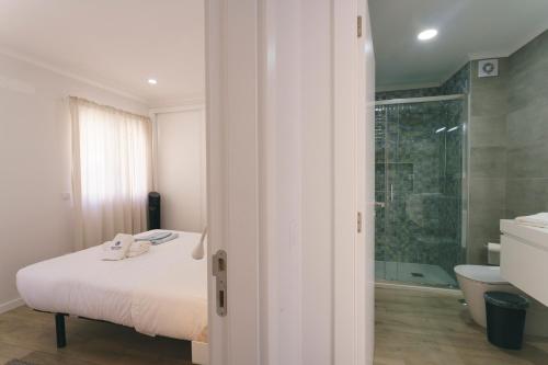 a bedroom with a bed and a bathroom with a shower at Best Houses 102 - Hut Spot Peniche in Peniche