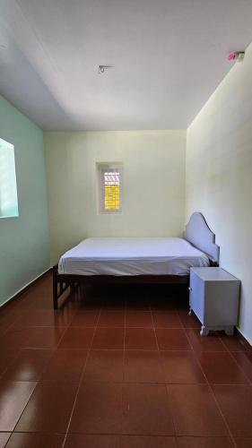 a small bedroom with a bed and a window at MARUTHY FARM HOUSE in Vandanmedu