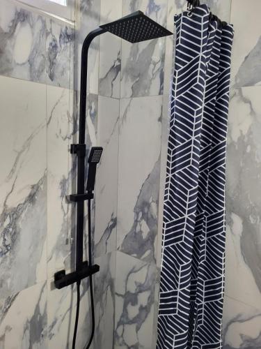 La salle de bains est pourvue d'une douche en noir et blanc. dans l'établissement Les Ondines, à Argelès-sur-Mer