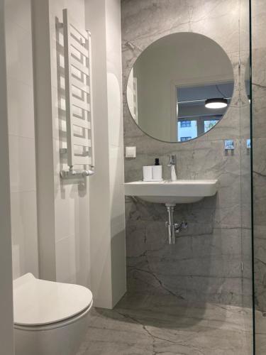 een badkamer met een toilet, een wastafel en een spiegel bij Enes Apartments Legnicka Street 59D in Wrocław